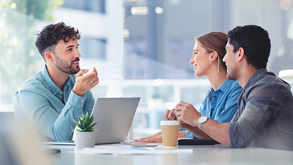 Three people in discussion at a table